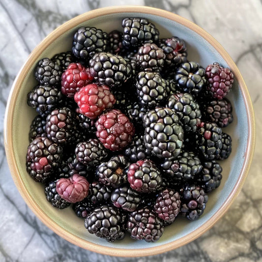 Bowl of Natchez blackberries on a marble surface